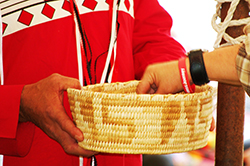 Hand grabbing tobacco from basket as offering